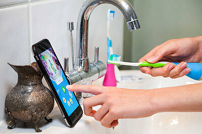 Der mehrfach ausgezeichnete Zahnbürstenaufsatz Playbrush verbindet sich via Bluetooth mit Zahnputzspielen auf dem Smartphone oder Tablet