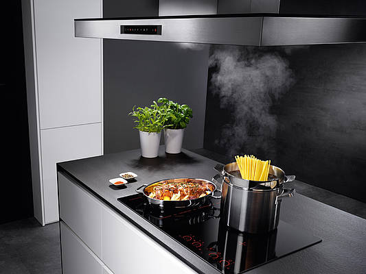 Das Induktionskochfeld kann mittels eines Infrarotsensors direkt mit der Dunstabzugshaube kommunizieren; nach dem Kochen schaltet sie sich automatisch ab (Foto: AMK)