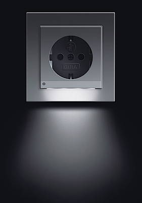 Intelligente Lösung: Gira bietet eine Steckdose mit Orientierungshilfe, die mit einem Lichtsensor ausgestattet ist (Bild: www.gira.de)
