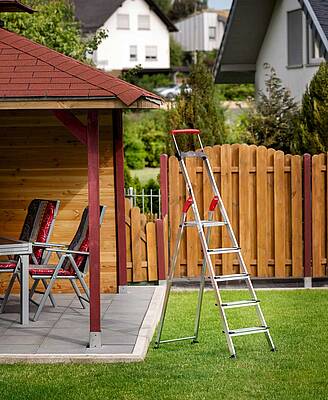Für sicheres Arbeiten am Gartenhaus: das Duo aus der Stehleiter HAILO L85 ComfortLine und dem Fuß-Wechsel-System EasyClix Garden
