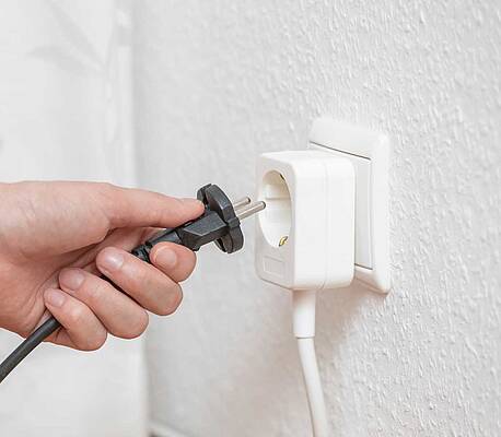 Die Extrasteckdose wird einfach auf die Wand geklebt und dient als neuer Stromverteiler